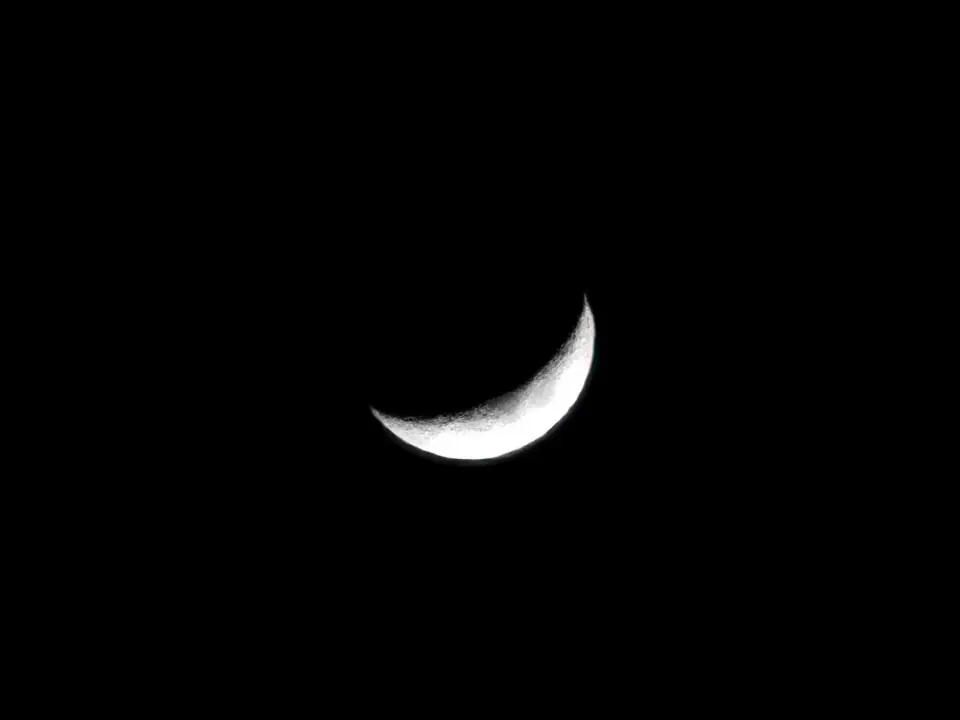 Eine schmale Mondsichel am dunklen Himmel